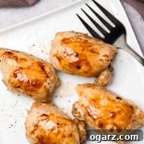 Golden Roasted Boneless Chicken Thighs 5 A square serving plate containing four boneless, skinless chicken thighs, roasted and glazed with honey and balsamic vinegar.