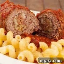Slow cooker Italian beef braciole, sliced to show the filling of salami, breadcrumbs, and cheese.