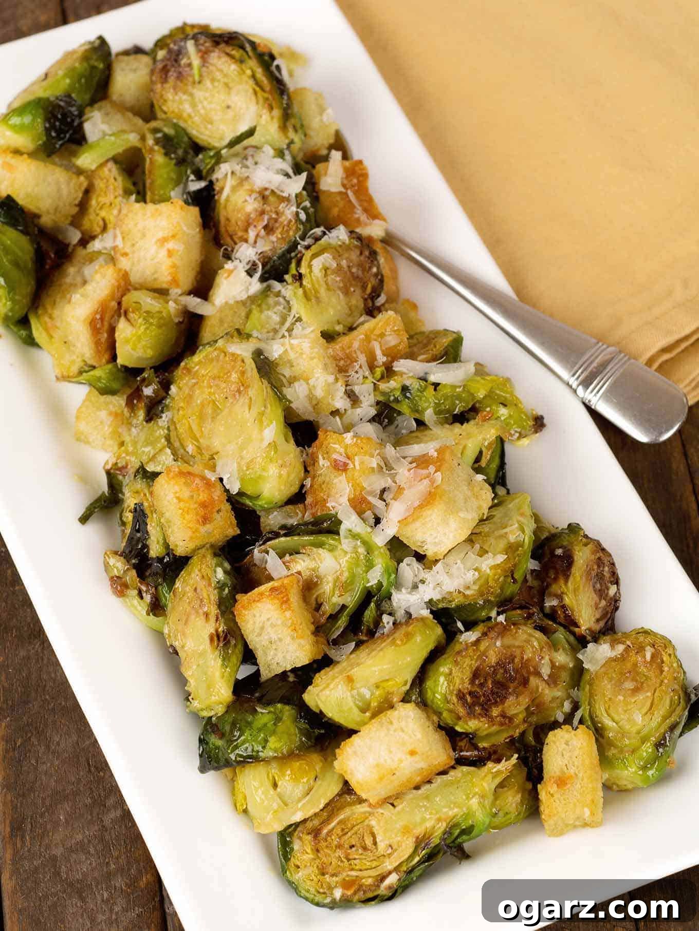 Shaved Brussels Caesar Salad 2 Warm Brussels sprouts Caesar salad with golden croutons and shaved Parmesan, elegantly arranged on a rectangular white platter. A perfect blend of roasted vegetables and classic flavors.