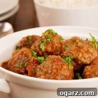 Moroccan lamb meatballs in spiced tomato sauce, garnished with parsley and served in a white bowl.