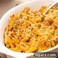 Baked barbecue chicken pasta in a white casserole dish, topped with melted cheese.