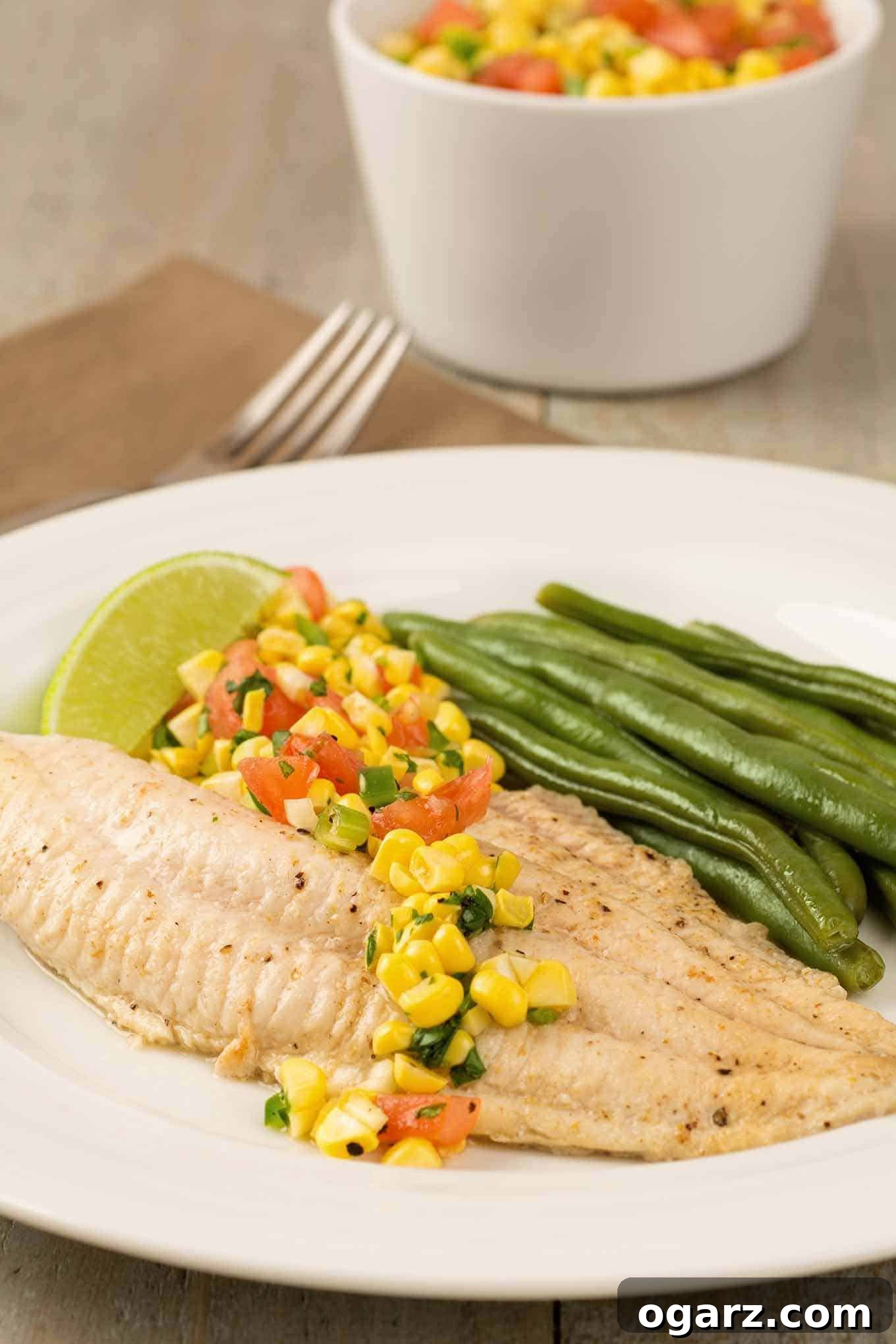 Grilled Catfish with Zesty Summer Salsa 2 A plate of broiled catfish filet topped with fresh corn salsa, steamed green beans, and a lime wedge. Broiled catfish fillets topped with fresh corn salsa make a light, satisfying dinner that goes from kitchen to table in less than 30 minutes.