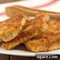Crispy breaded pork chops, shallow-fried to golden perfection, stacked on a plate.