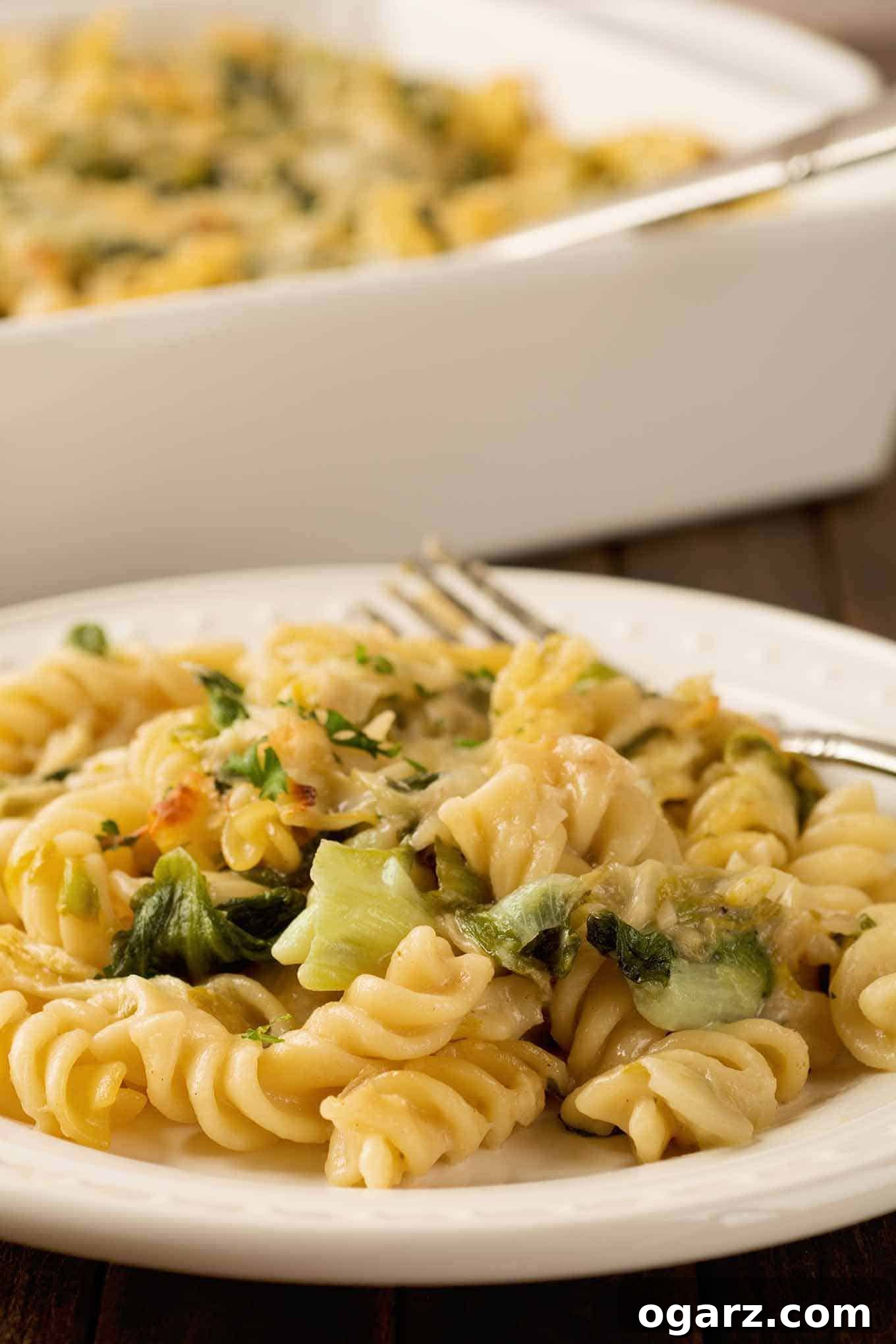 Cheesy Garlic Parmesan Pasta Bake 4 A close-up photo of rotini pasta tossed with sautéed escarole and a creamy, garlic and Parmesan cheese sauce.