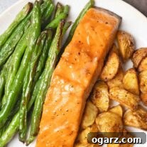 Fırından Tek Tepsi Lezzeti: Somon, Patates ve Taze Fasulye 6 A single serving of sheet pan salmon dinner including brown sugar-glazed salmon, roasted baby potatoes, and green beans.