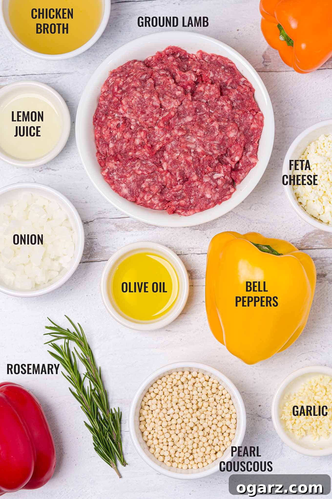Greek Yemista 3 An overhead view of the labeled ingredients needed to make Greek stuffed peppers including bell peppers, ground lamb, couscous, feta cheese, and more.