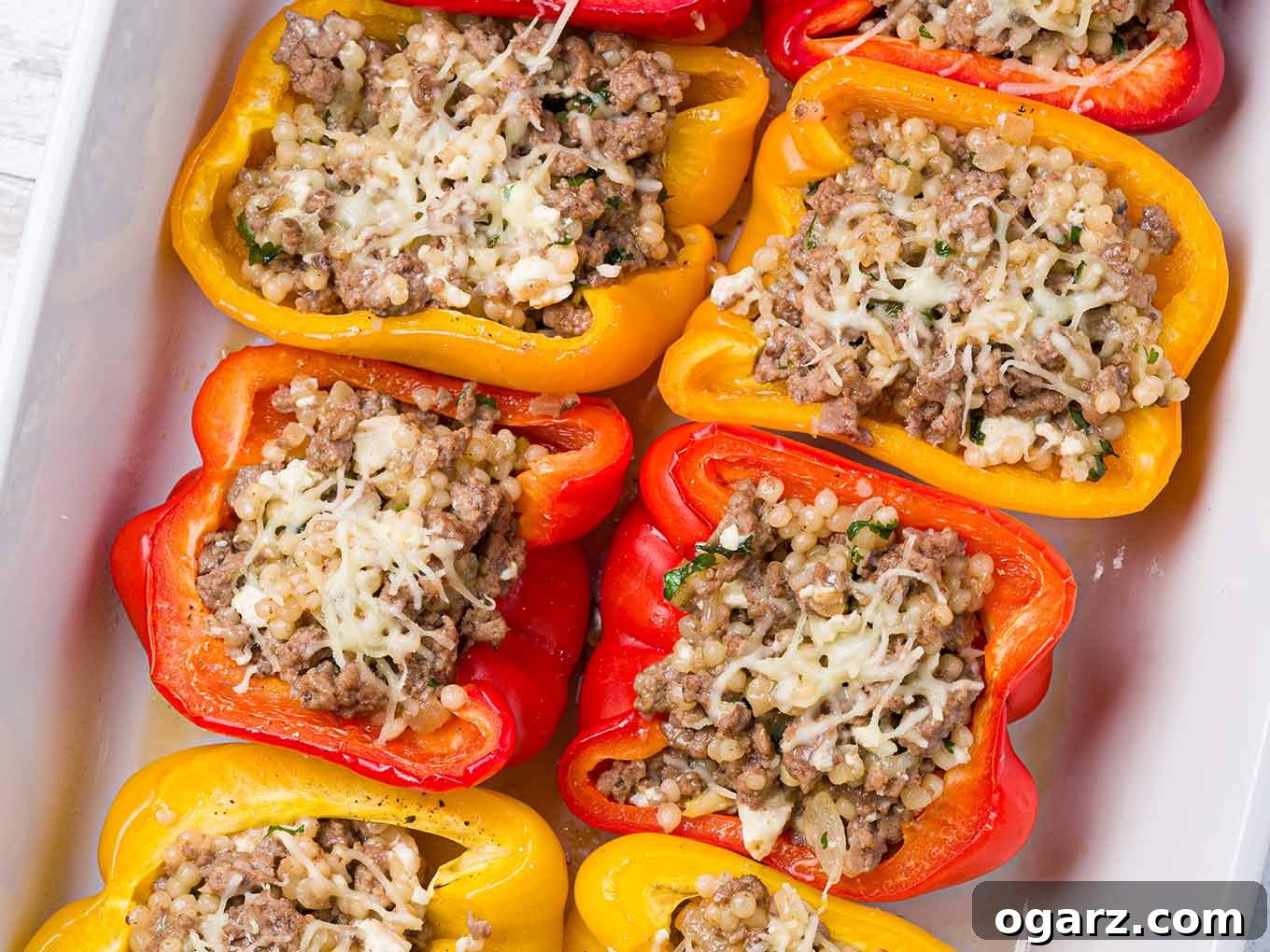 Greek Yemista 6 Red, orange, and yellow bell peppers filled with ground lamb, pearl couscous, and feta cheese, baked and topped with finely shredded melted mozzarella.