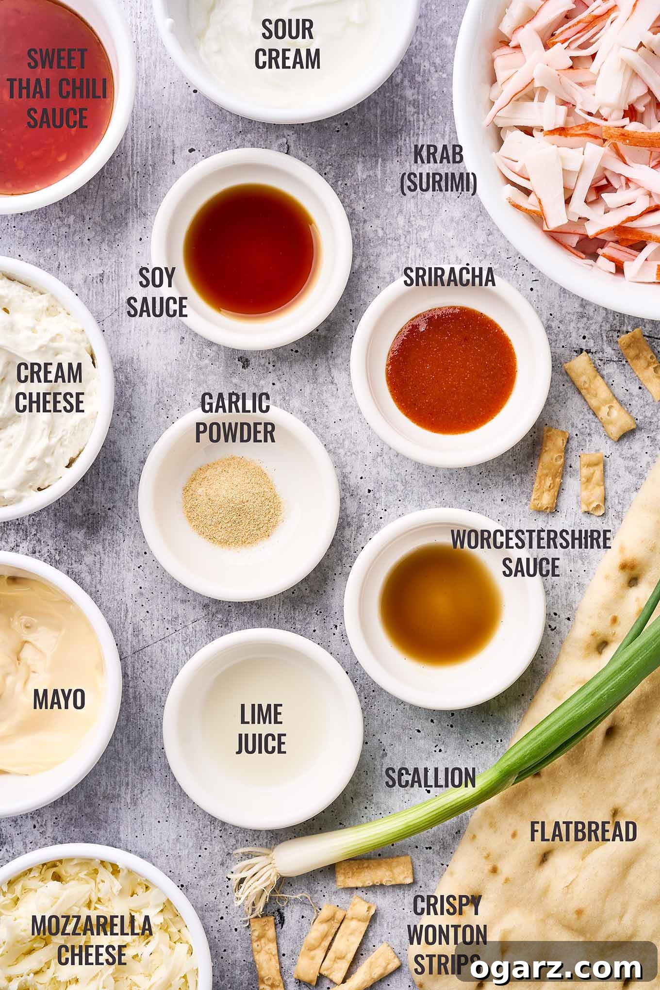Crab Wonton Pizza 3 A labeled, overhead view of the ingredients for crab Rangoon flatbread pizza including krab (surimi), cream cheese, sour cream, mayo, flatbread, wonton strips, and more.