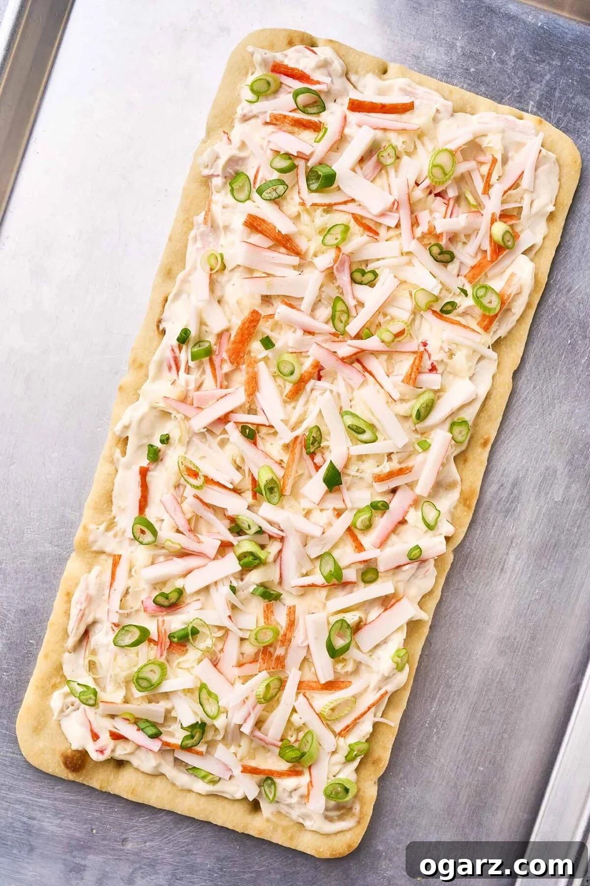 Crab Wonton Pizza 5 A fully-assembled crab Rangoon flatbread on a baking sheet, ready for the oven.