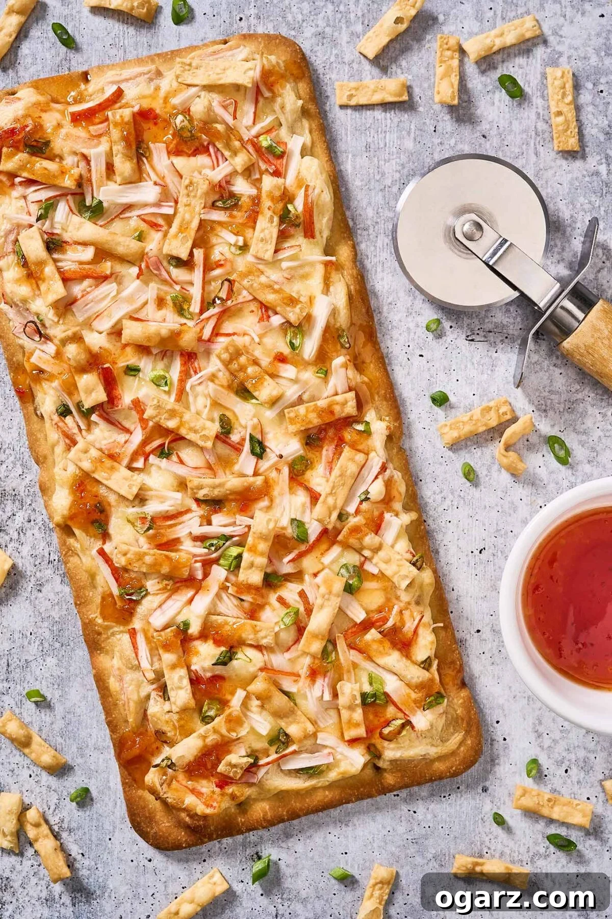 Crab Wonton Pizza 6 A whole crab Rangoon flatbread pizza ready to be cut into appetizer-sized serving pieces.