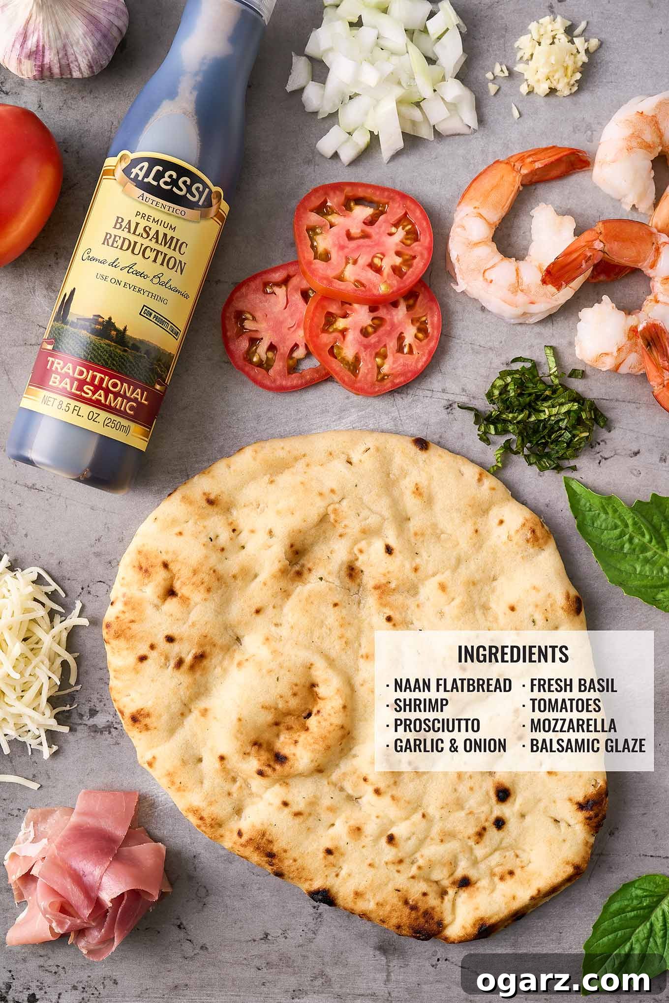 Ingredients needed for naan pizzas with prosciutto-wrapped shrimp arranged on a gray background and labeled.