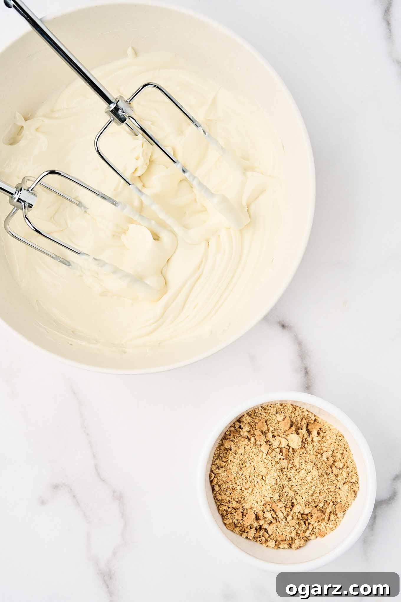 S'mores Parfaits 4 A mixing bowl filled with cream cheese whipped together with Greek vanilla yogurt and vanilla extract, beaters in the bowl, a separate bowl of graham crackers to the side.