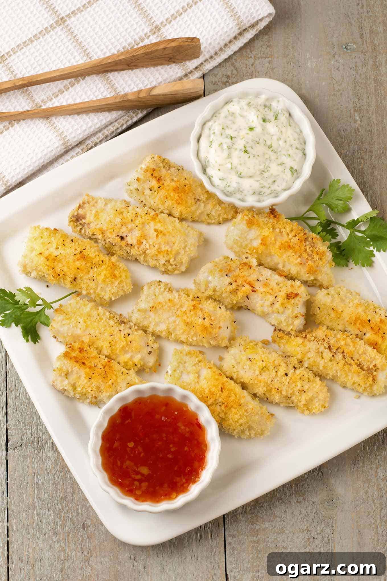 Baked Ginger-Soy Fish Sticks 2 Panko-crusted, oven baked fish sticks on a serving plate with sweet Thai chili sauce and an Asian-style tartar sauce.