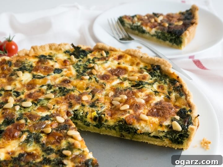 A whole Spinach Quiche with Cheese and Pine Nuts, freshly baked and golden brown, sliced on a rustic wooden board.