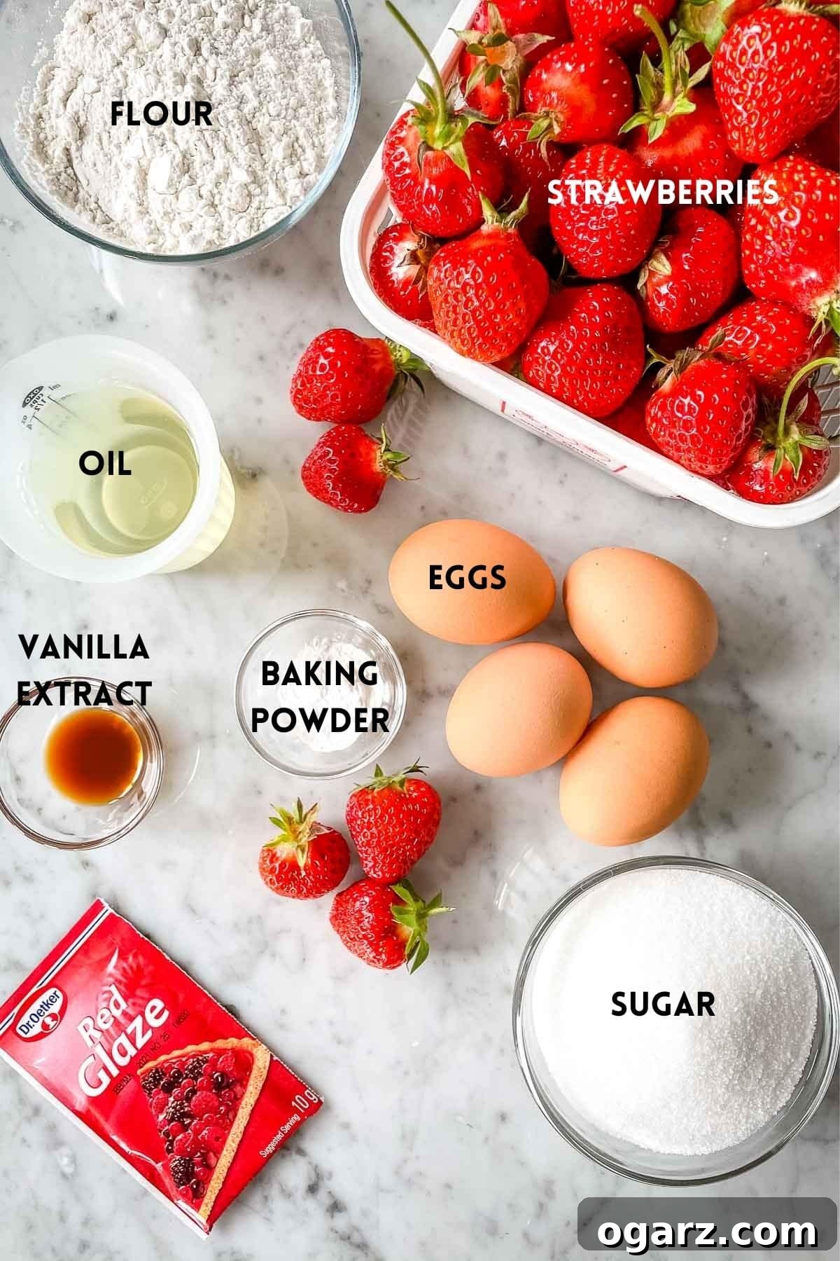 German Strawberry Kuchen 3 A flat lay photograph showcasing all the ingredients required for baking a German Strawberry Cake: fresh strawberries, eggs, flour, sugar, oil, baking powder, vanilla, and a packet of red glaze.