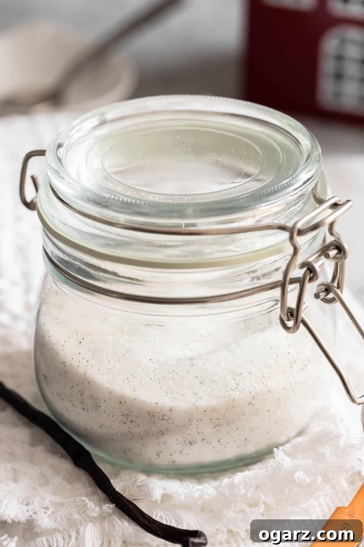 A closed jar filled with sugar and vanilla beans.