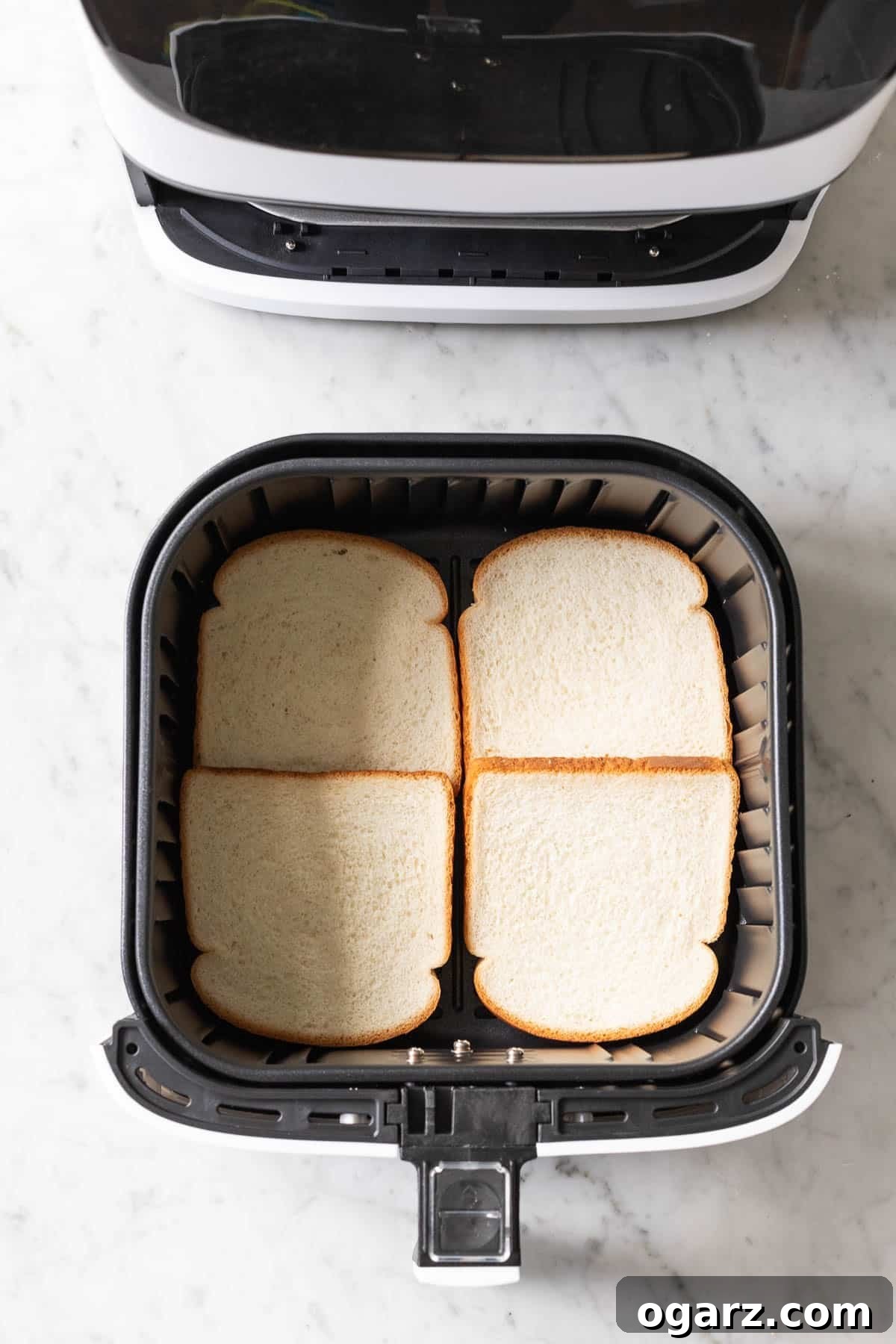 Crispy Air Fryer Toast 4 Bread slices arranged neatly in an Air Fryer basket, ready to be toasted.
