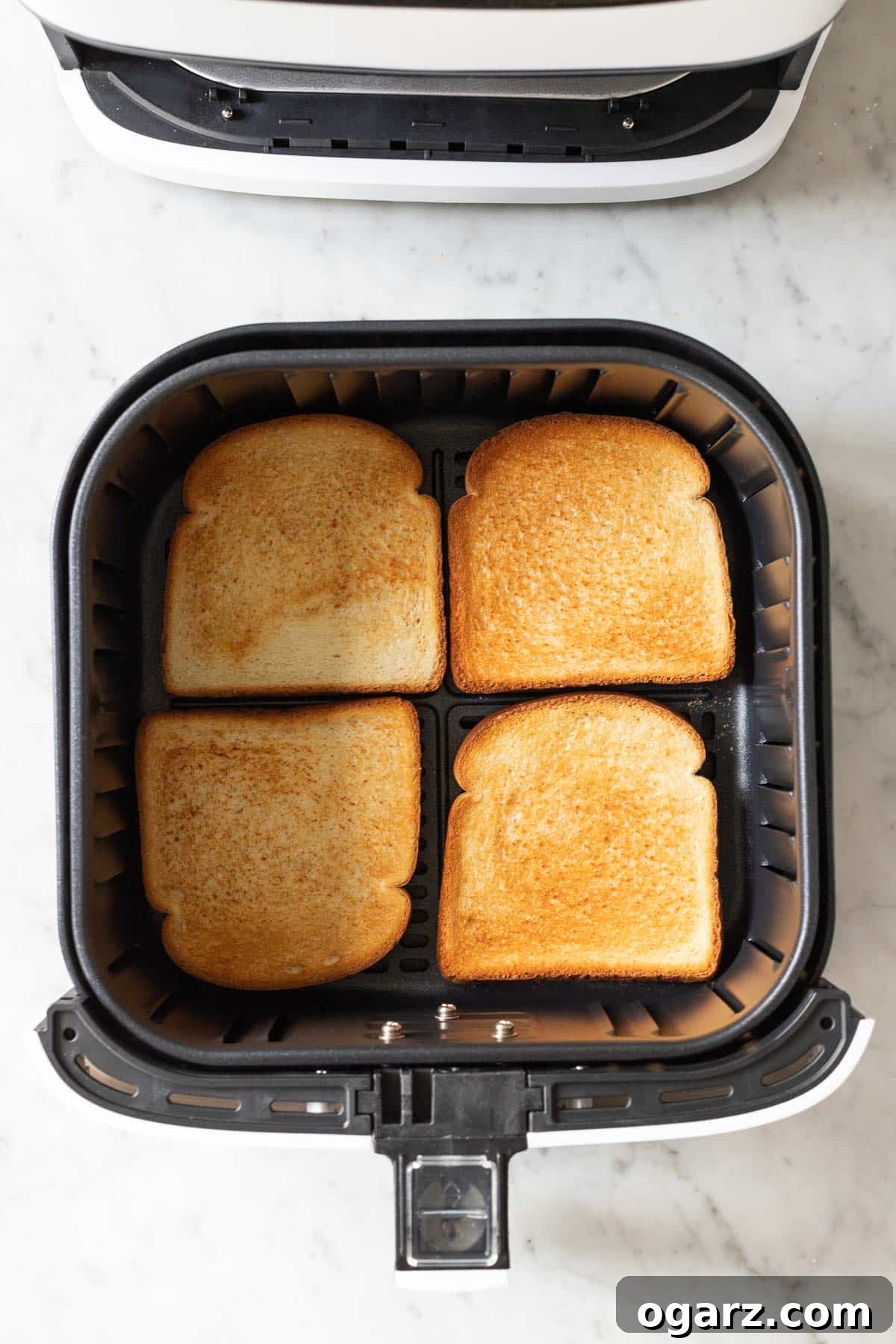 Crispy Air Fryer Toast 5 Toasted bread pieces arranged in an Air Fryer basket, ready to be served.