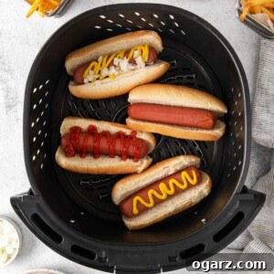 Golden Crispy Air Fryer Hot Dogs 7 Hot Dogs in an air fryer basket, showing the perfect crisp.