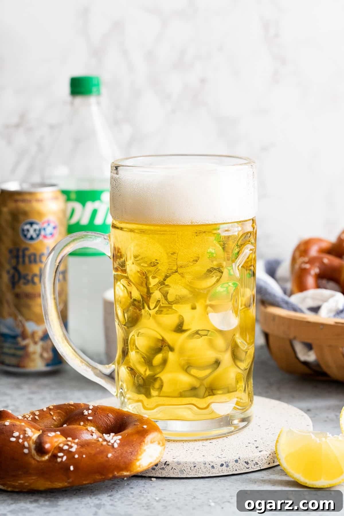 Zesty Lager Blend 2 A beer stein next to a pretzel and a slice of lemon, evoking the refreshing taste of Radler beer.