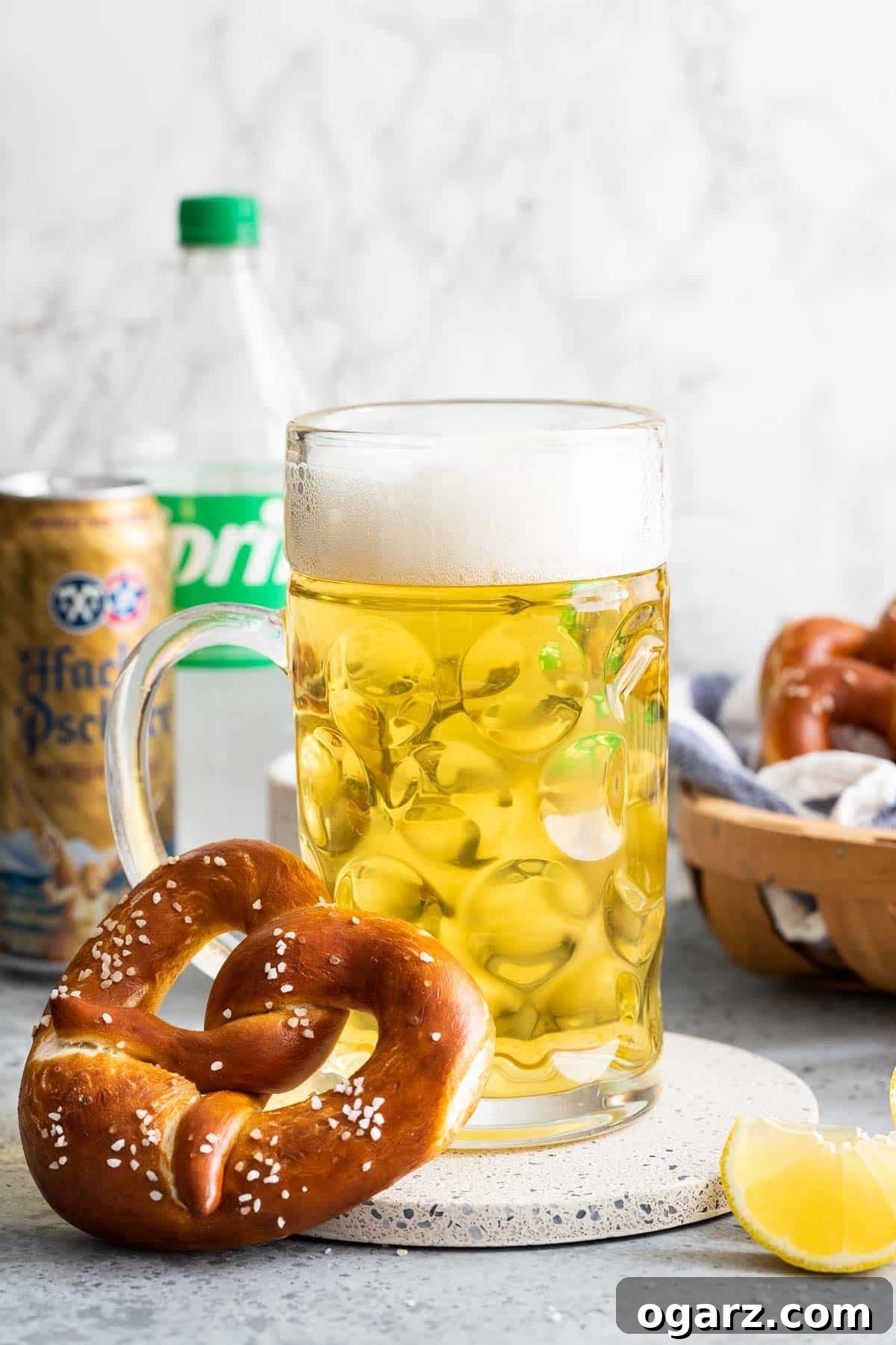 Zesty Lager Blend 7 A pretzel leaning on a beer stein filled with Radler, showcasing a perfect pairing.