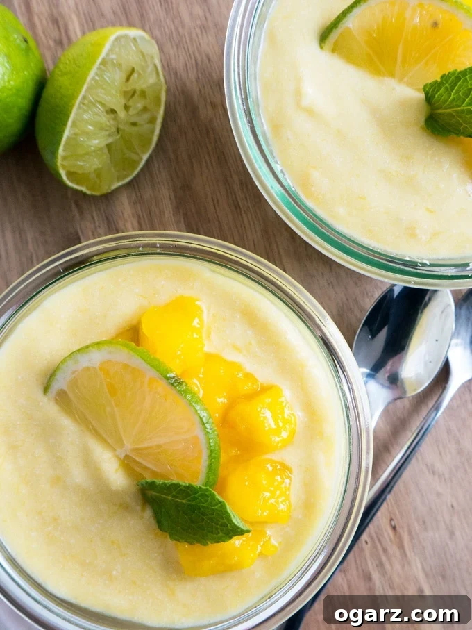 Tropical Vegan Mango Coconut Rice Pudding 4 A beautifully presented jar of vegan mango rice pudding with coconut, garnished with mint and a lime wedge, ready for breakfast or brunch.