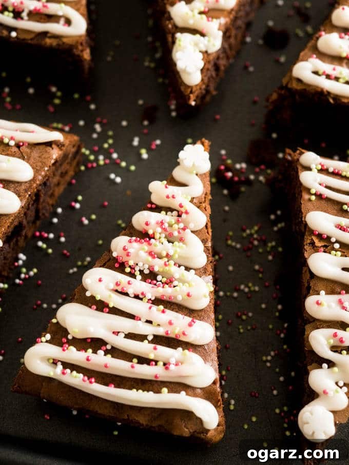 Festive Gingerbread Brownies 2 Close-up of a decorated Gingerbread Christmas Brownie, shaped like a Christmas tree, on a wooden surface.