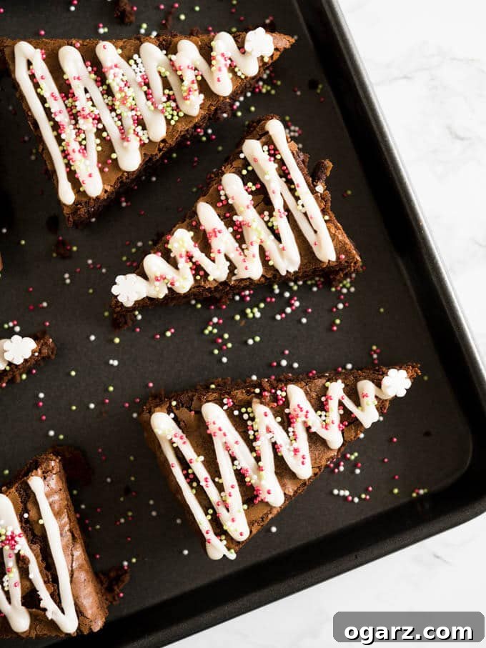 Festive Gingerbread Brownies 5 A beautifully decorated Gingerbread Christmas Tree Brownie with white icing zigzags and colorful sprinkles, ready to be enjoyed.
