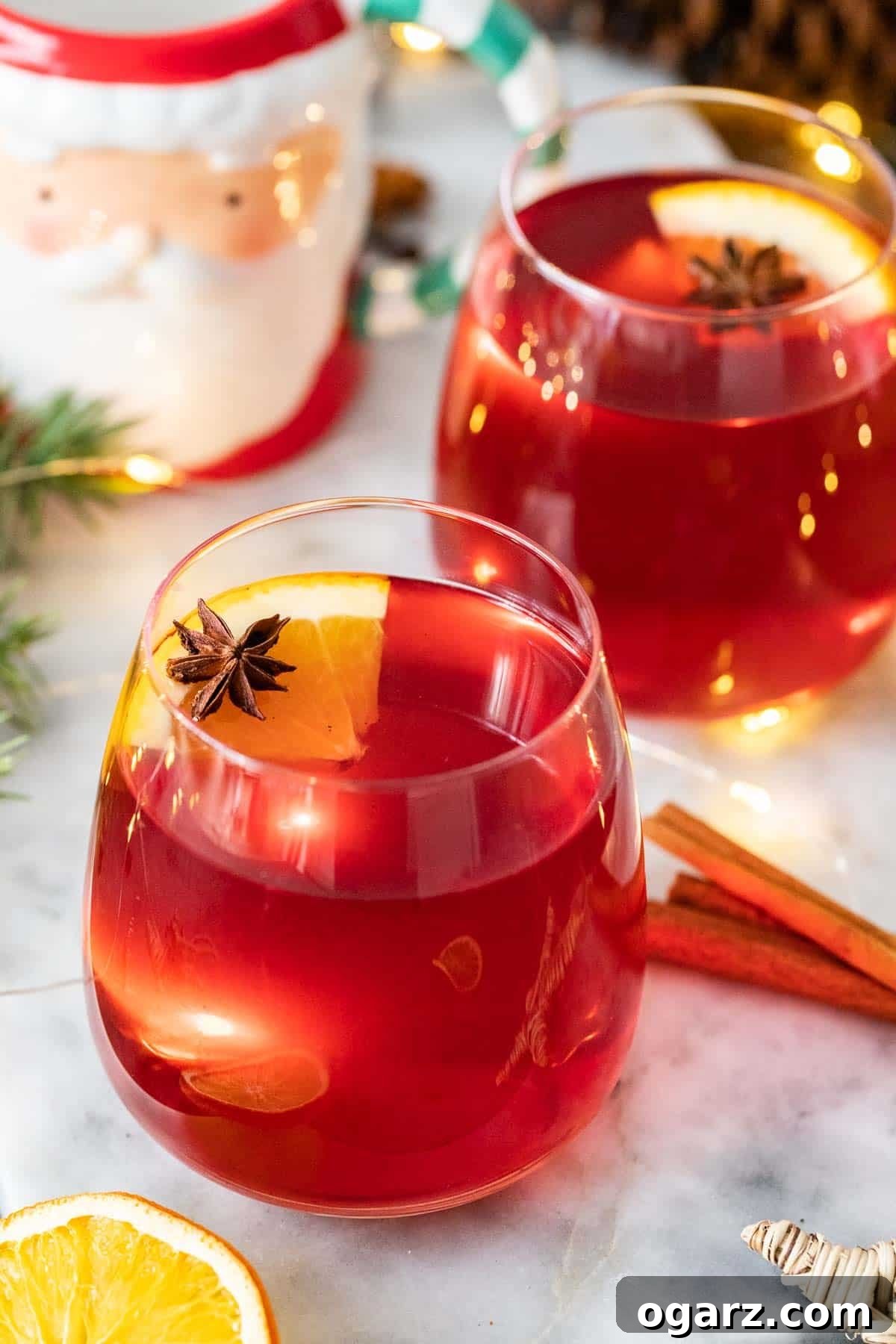 Festive Kids' Punch 2 Two glass mugs filled with Kinderpunsch garnished with orange slices and star anise.