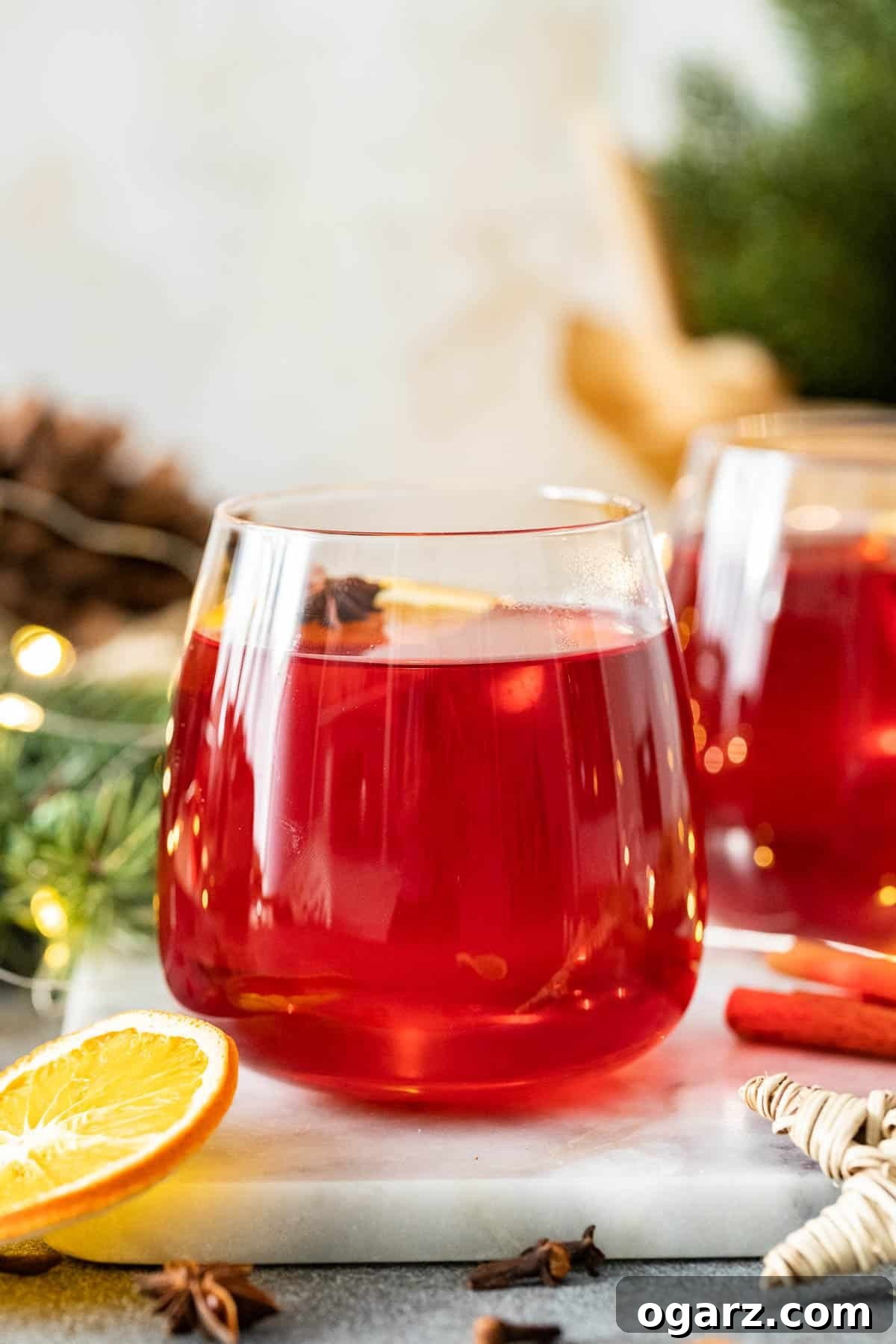 Festive Kids' Punch 6 A glass filled with non-alcoholic Christmas Punch on a marble board.