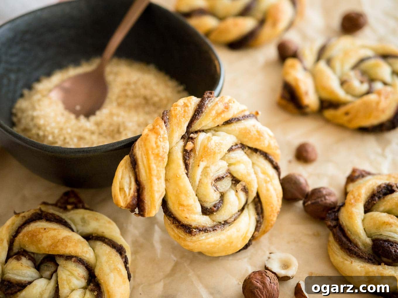 Simple Swirl Nutella Danish 9 A top-down view of several Twisted Nutella Danish pastries arranged artfully on a wooden board, ready to be enjoyed.