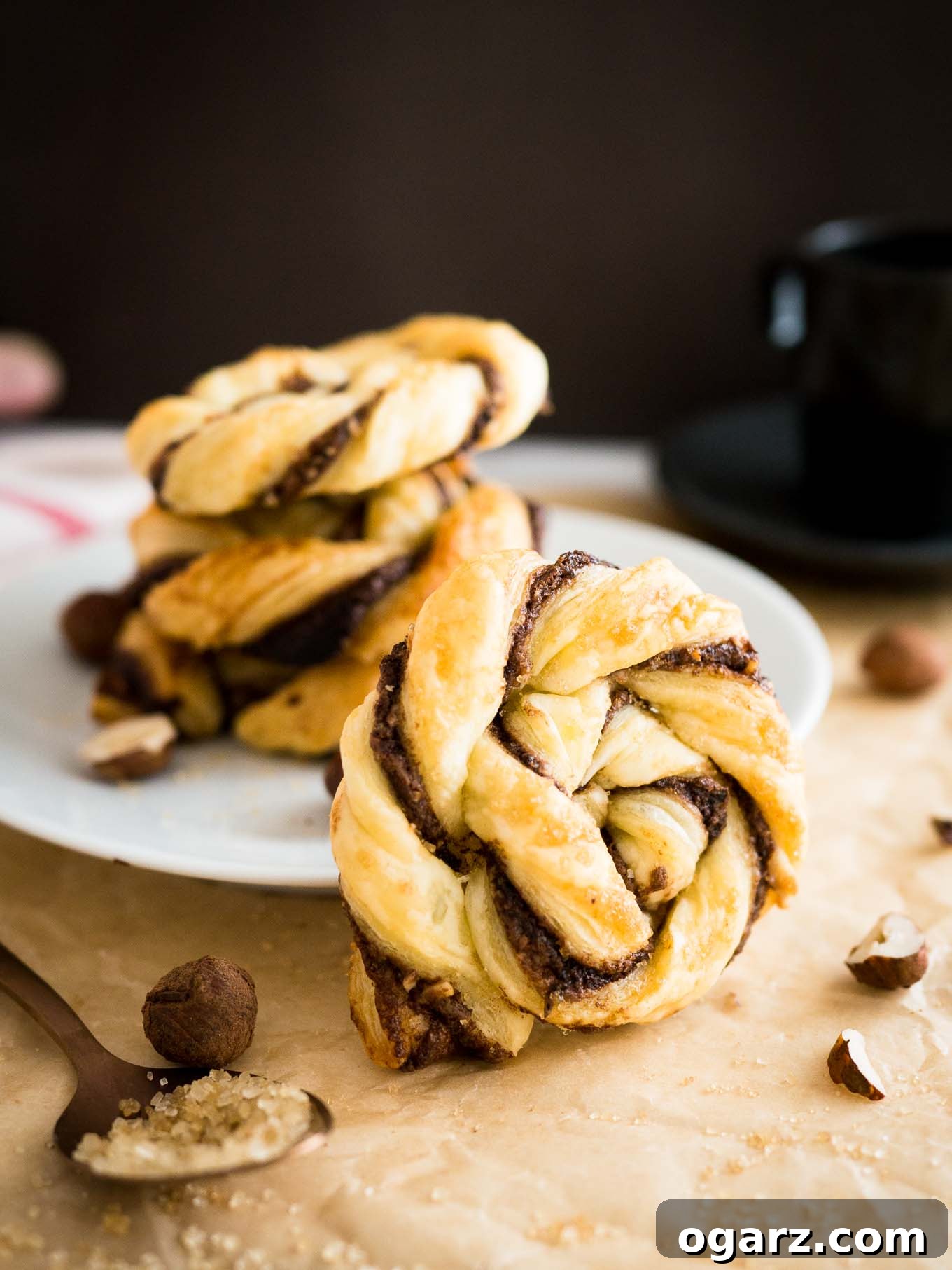 Simple Swirl Nutella Danish 7 Baked Twisted Nutella Danish pastries, golden brown and garnished with powdered sugar, ready to be served.
