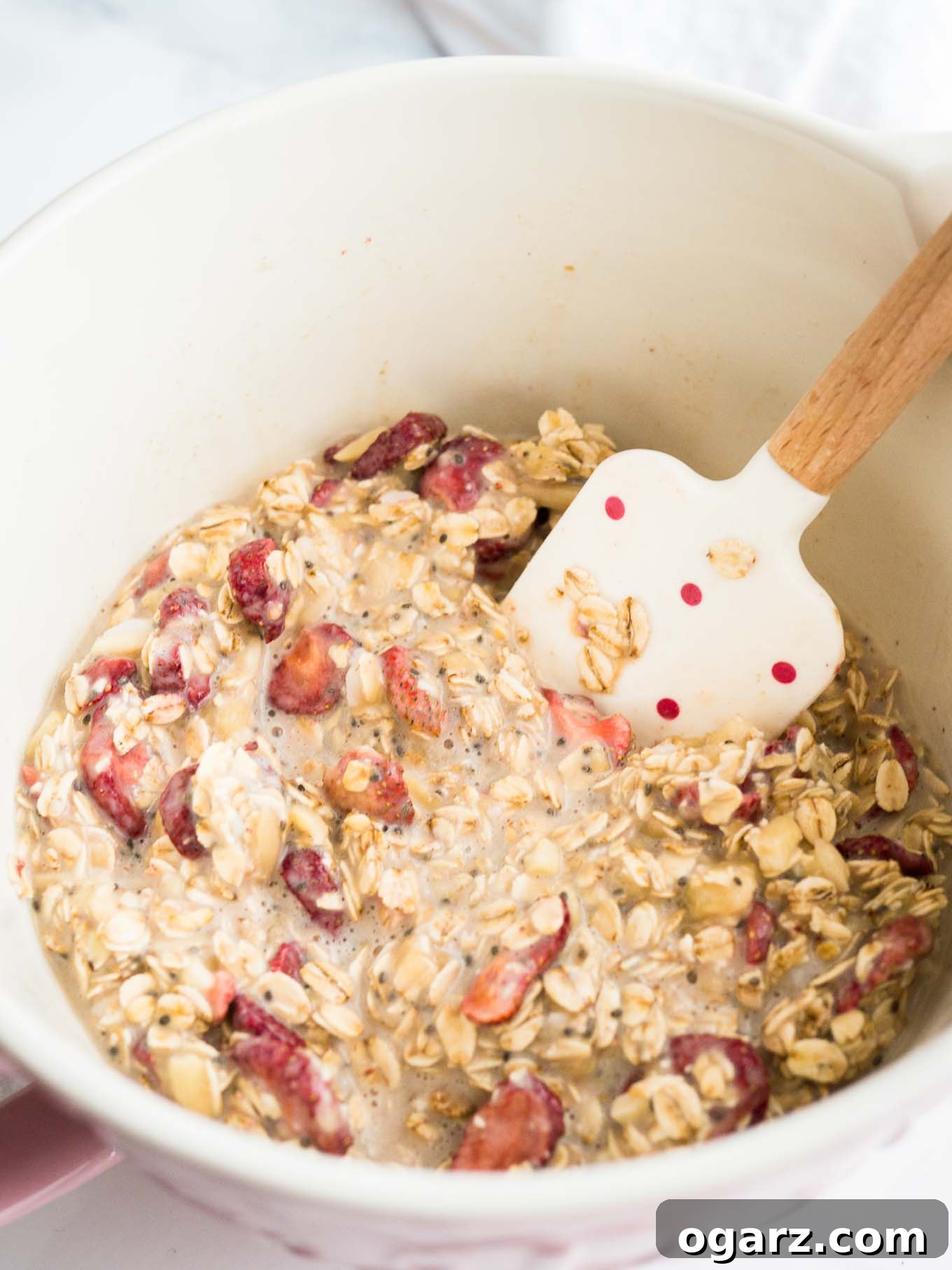 Healthy Strawberry Baked Oatmeal Cups 4 Two Strawberry Baked Oatmeal Cups on a rustic plate, garnished with whole freeze-dried strawberries and a sprig of mint, ready to eat.