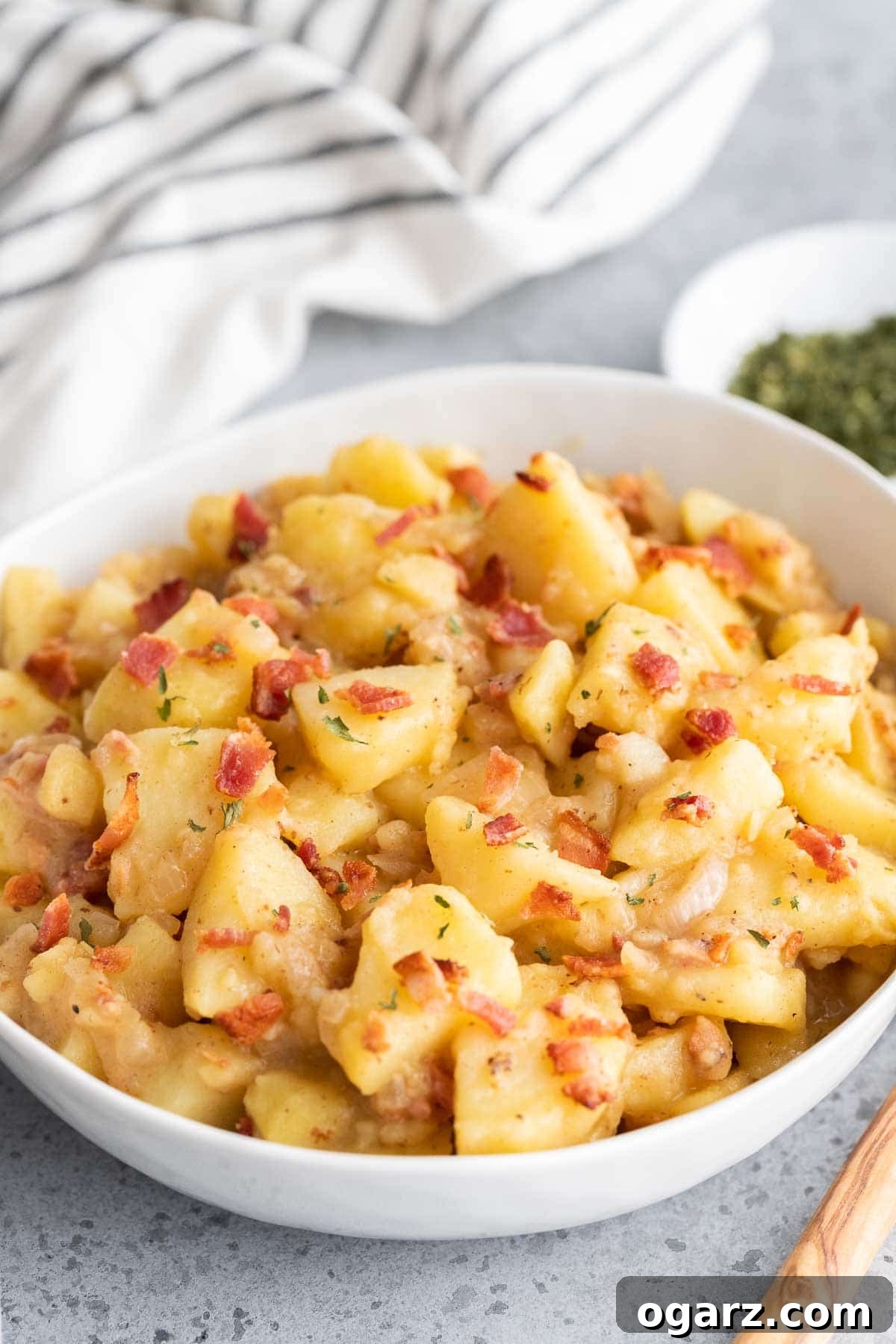 German Potato Salad in a white bowl, ready to serve