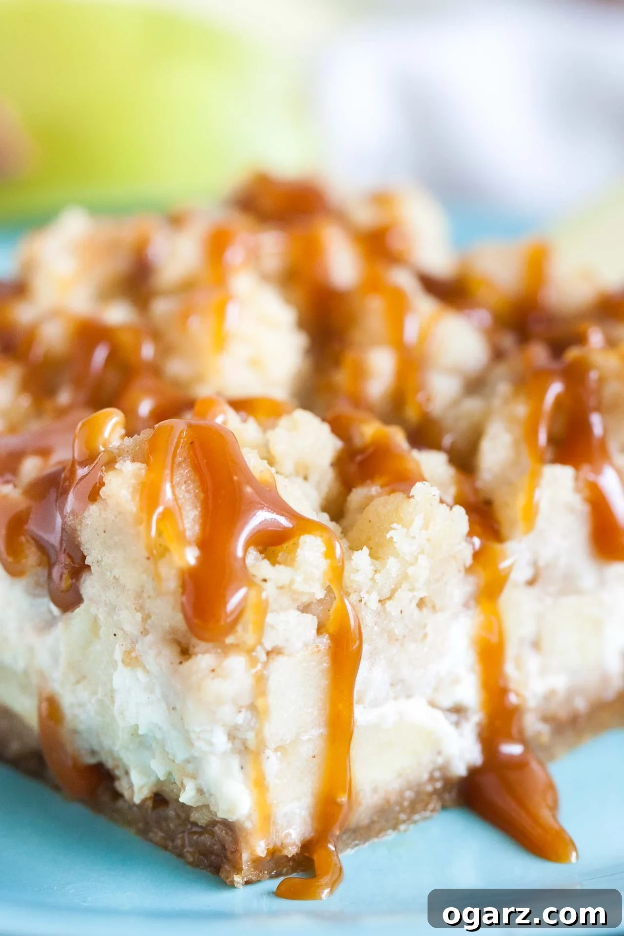 Salted Caramel Apple Cheesecake Bars 7 Close-up of a teal plate with a caramel apple cheesecake bar.