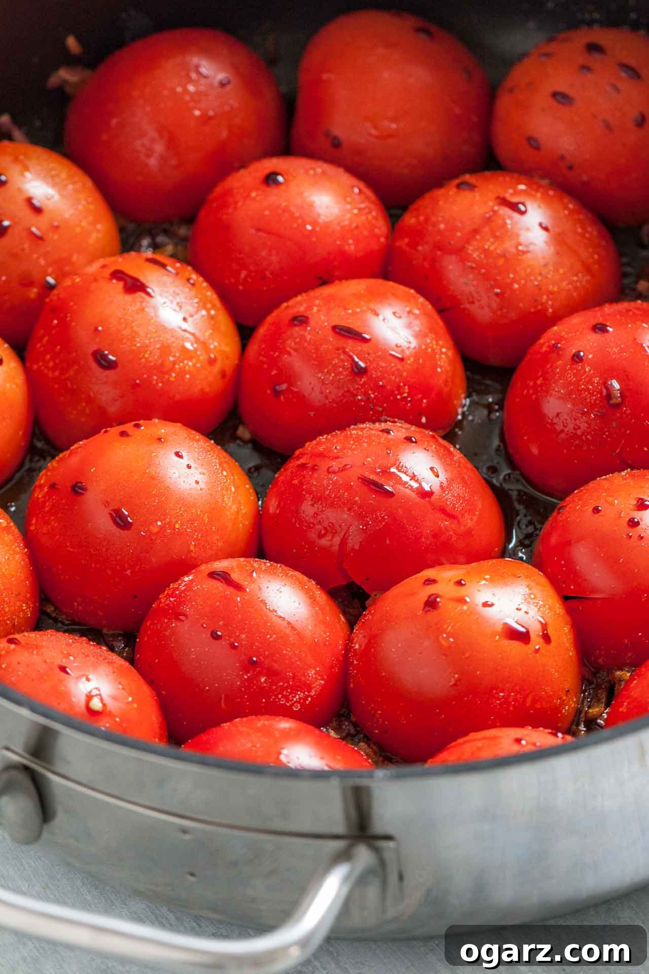 Golden Roasted Tomato Velouté 4 A pan of halved tomatoes lying cut side down, with some balsamic vinegar.