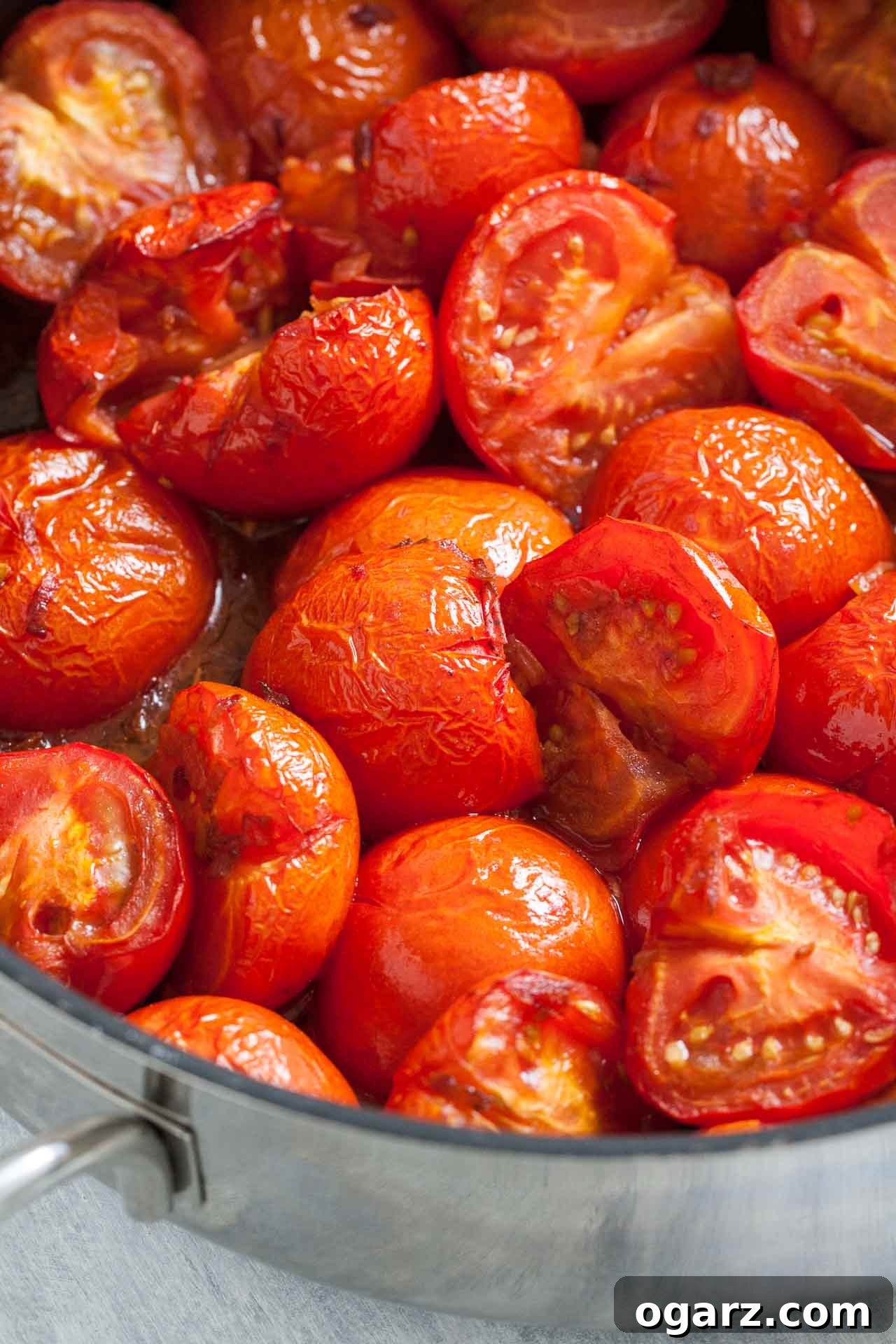 Golden Roasted Tomato Velouté 5 Roasted tomatoes with wrinkly skin in a large pan.