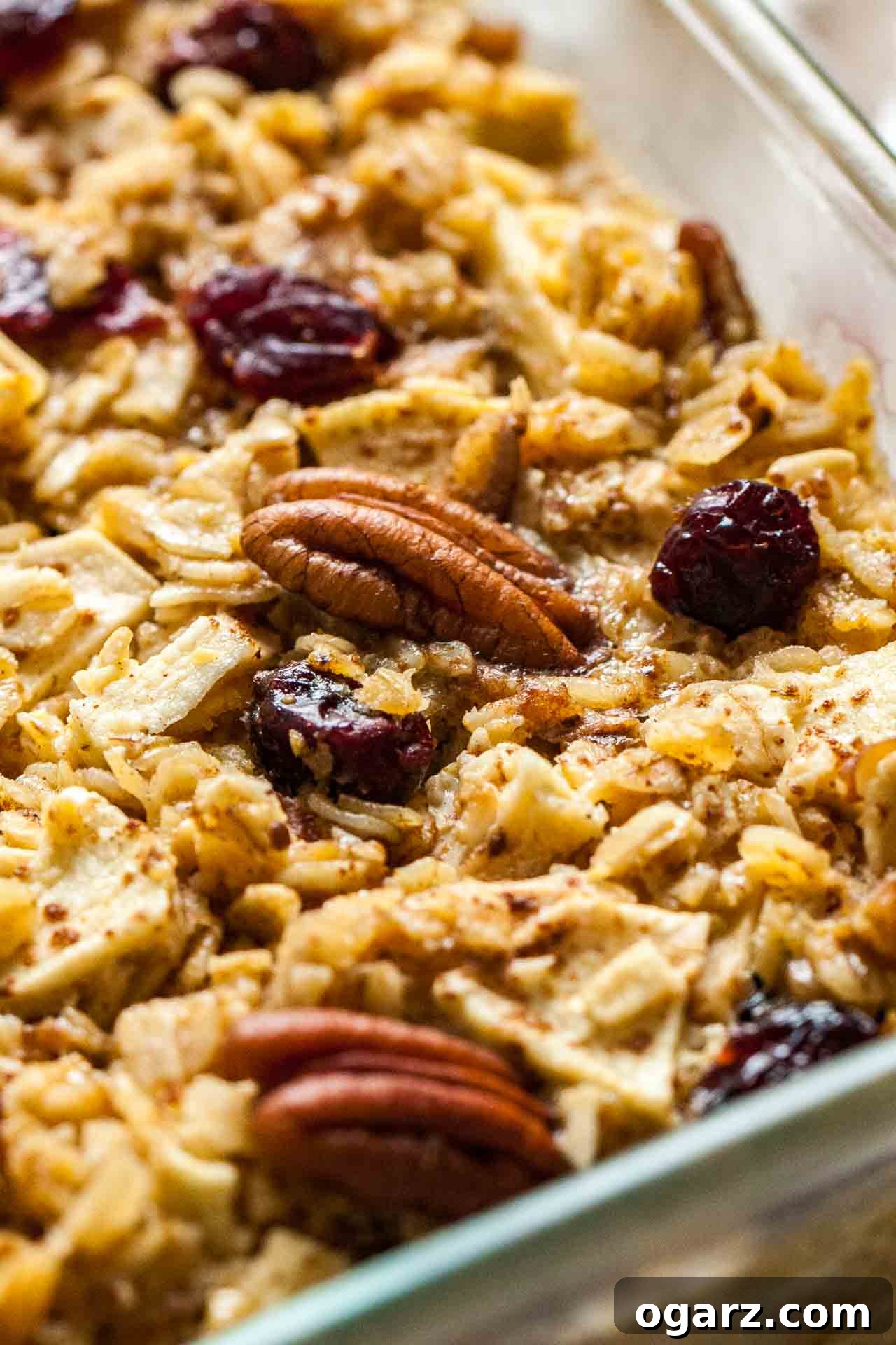 Wholesome Baked Oatmeal 5 Close-up of a glass baking dish with baked oatmeal with apples, pecans and cranberries, ready to be served.