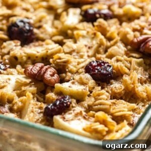 Wholesome Baked Oatmeal 6 Close-up of a glass baking dish with baked oatmeal with apples, pecans and cranberries.