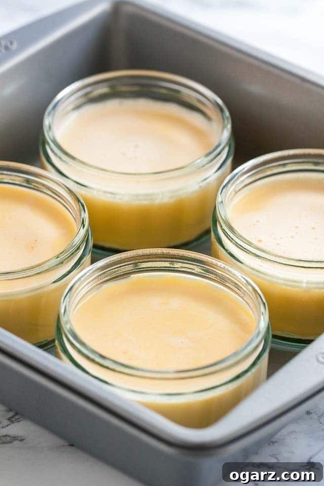 Foolproof Creme Brulee Recipe 4 4 glasses of creme brulee without the sugar topping in a grey baking pan.