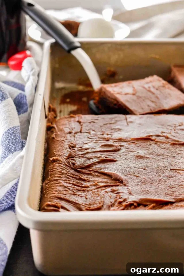 coca cola cake in a baking sheet with a spatula taking a piece out
