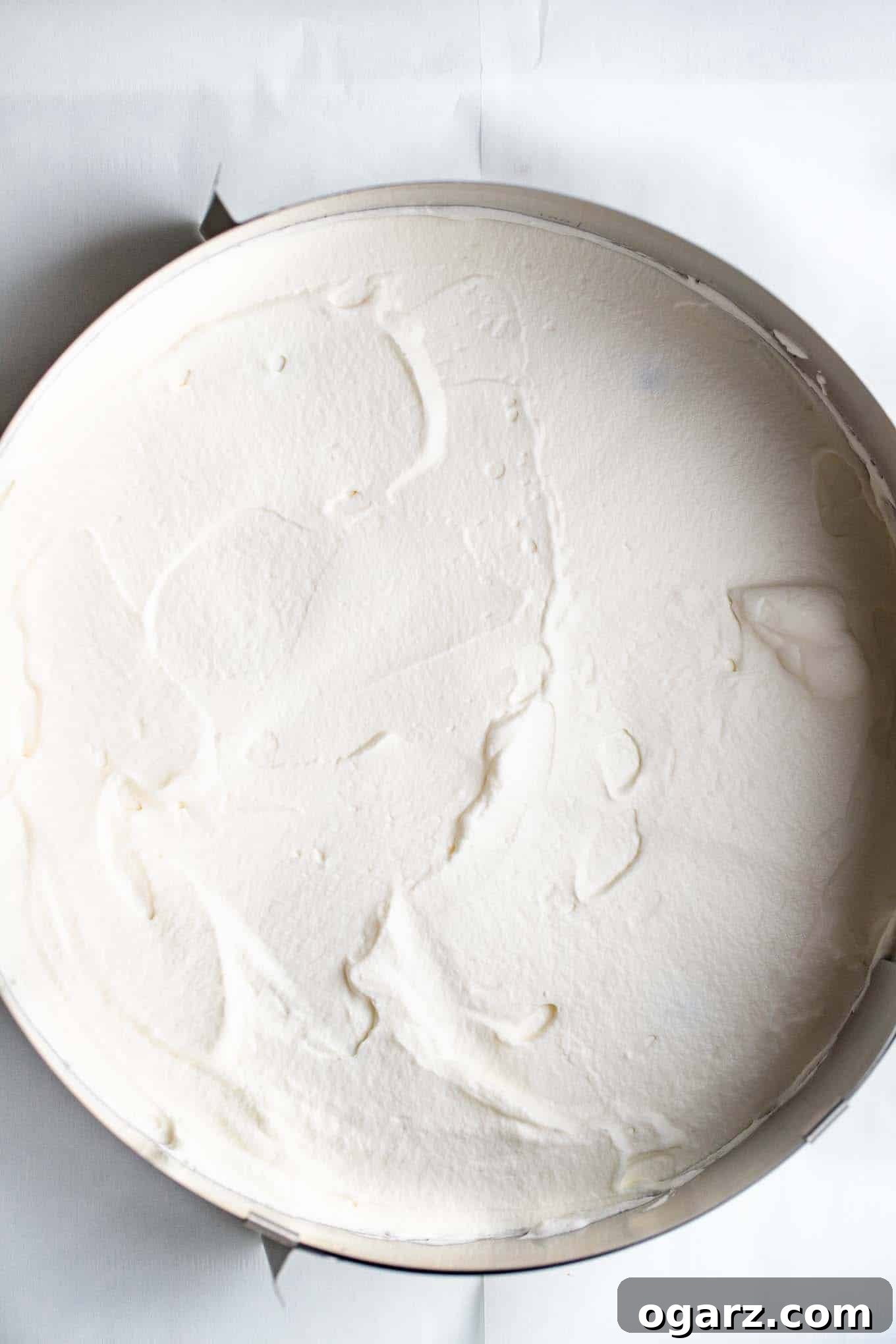 Dark Forest Cherry Delight 10 A fluffy layer of freshly whipped cream spread smoothly over the cherry filling on a cake layer, ready for the next tier.