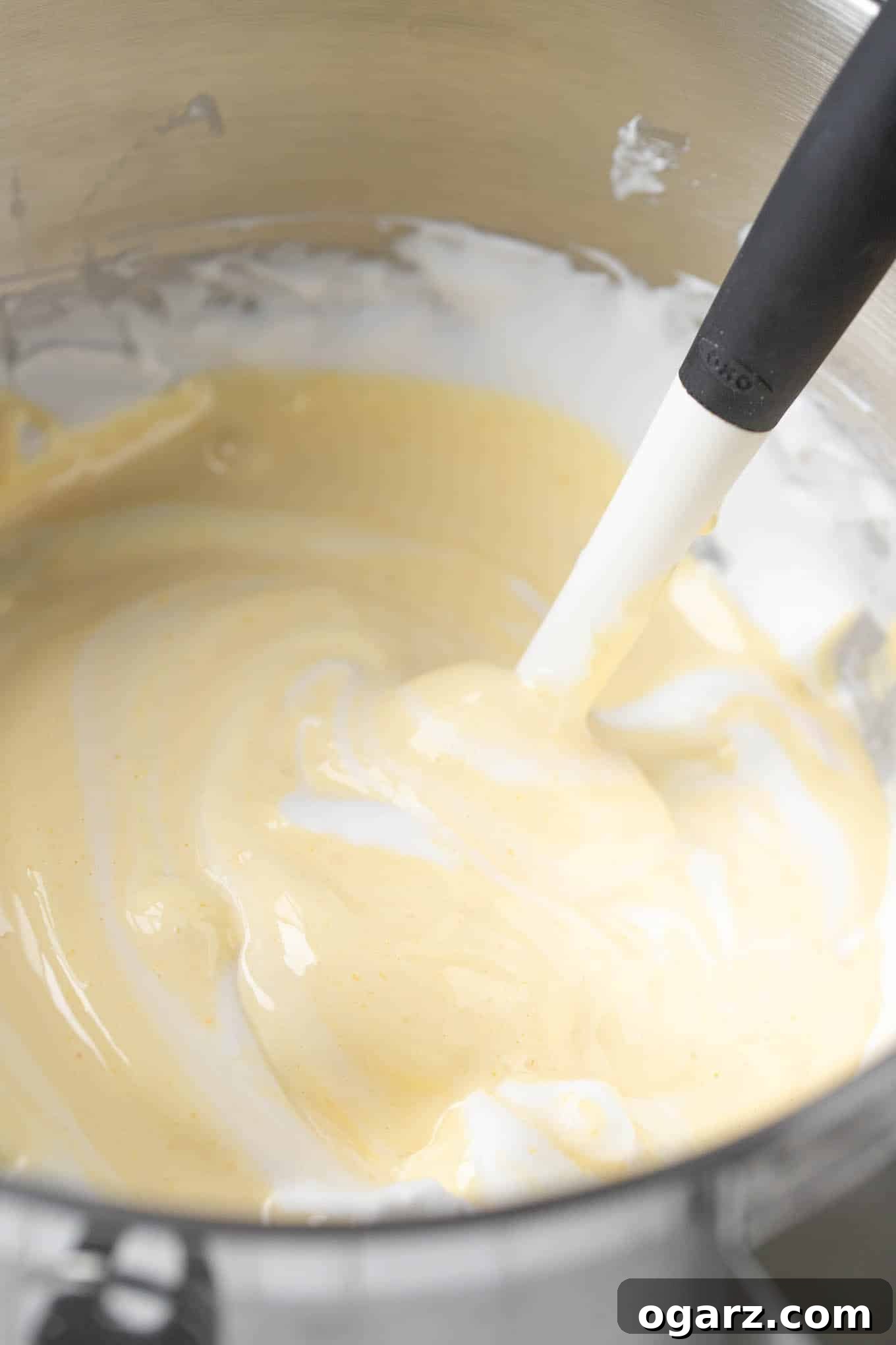 Dark Forest Cherry Delight 5 A vibrant yellow mixture of egg yolks, sugar, and vanilla extract, whipped to a thick and pale consistency in a mixing bowl.