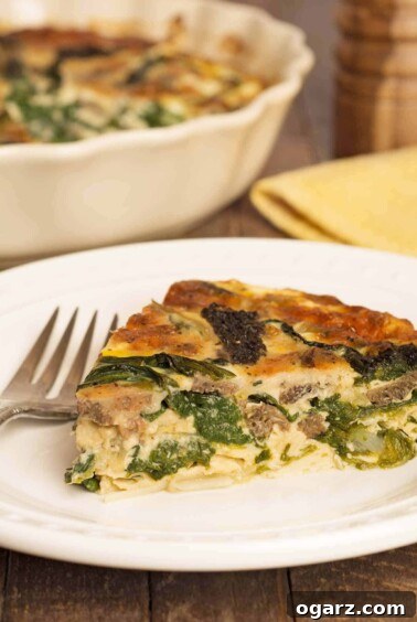 A close view of a slice of crustless morel mushroom and ramp quiche of a plate, a fork to the side and the dish with more quiche in the background, a lighter make-ahead option.
