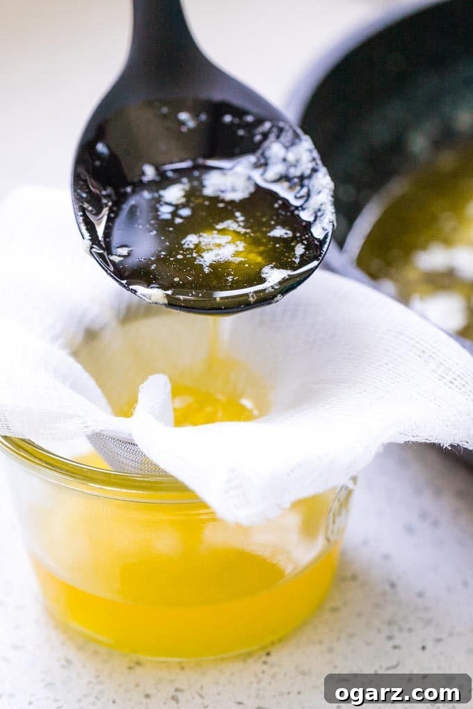 Golden Butter's Pure Essence 4 Clarified Butter being strained through a cheese cloth into a glass jar.