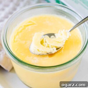 Clarified butter in a glass jar with a spoon sticking out.
