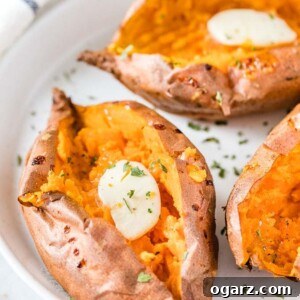 Perfect Air Fryer Sweet Potatoes 5 Air Fryer Sweet Potatoes on a plate topped with butter and parsley