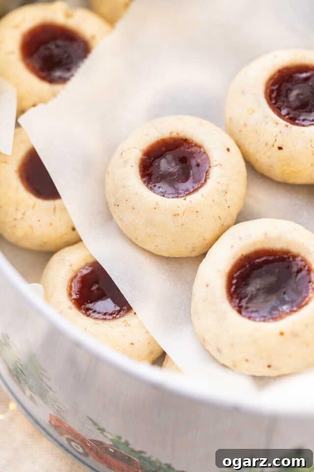 Jam Drop Delights 4 Cookies stored neatly in a metal tin, separated by layers of parchment paper for freshness and presentation.