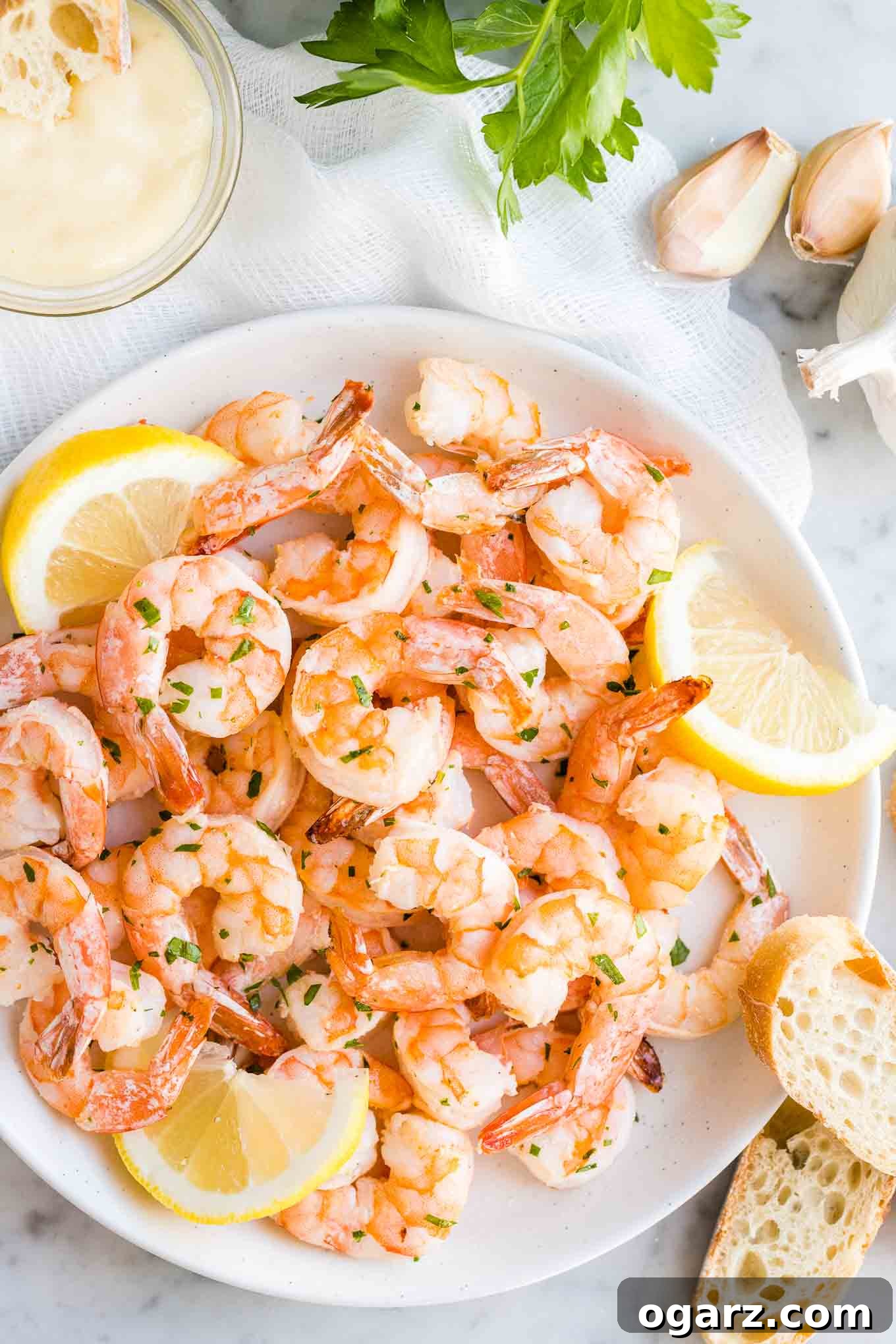 Air-fried garlic lemon shrimp served on a plate with fresh lemon wedges and crusty bread