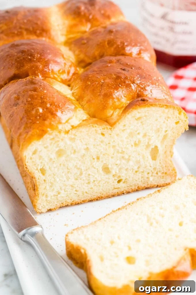 A freshly baked, golden-brown loaf of brioche bread resting on a serving tray, showcasing its appealing crust and shape.